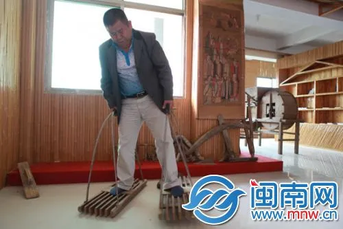 村民展示畲族传统田间劳动工具